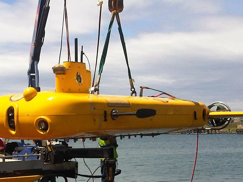 Sub-surface AUV with Underwater SPECTRE Marine Autopilot installed being lowered into water